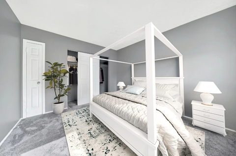 a bedroom with grey walls and a white four poster bed